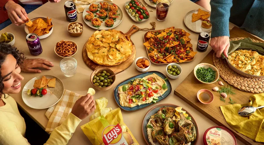 A table spread with PepsiCo snacks and beverages